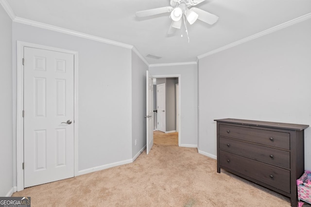 unfurnished bedroom featuring a ceiling fan, light carpet, crown molding, and baseboards
