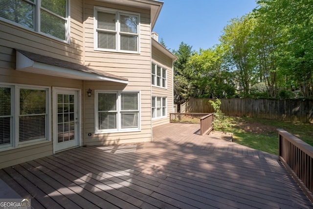 wooden deck with a fenced backyard