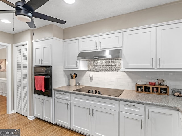 kitchen featuring black appliances, under cabinet range hood, ceiling fan, white cabinetry, and light wood-type flooring