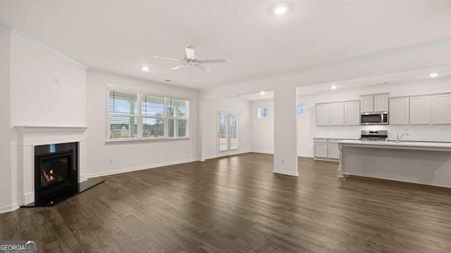 1099 Blue Juniper Cir, Loganville, GA 30052 - unfurnished living room featuring recessed lighting, baseboards, dark wood finished floors, a ceiling fan, and a glass covered fireplace