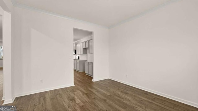1099 Blue Juniper Cir, Loganville, GA 30052 - empty room featuring dark wood-style floors, baseboards, and crown molding