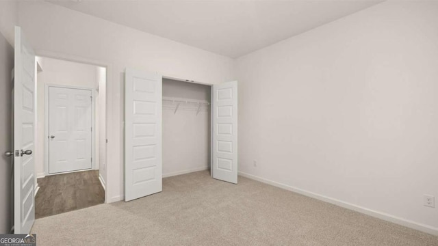 1099 Blue Juniper Cir, Loganville, GA 30052 - unfurnished bedroom with baseboards, a closet, and carpet