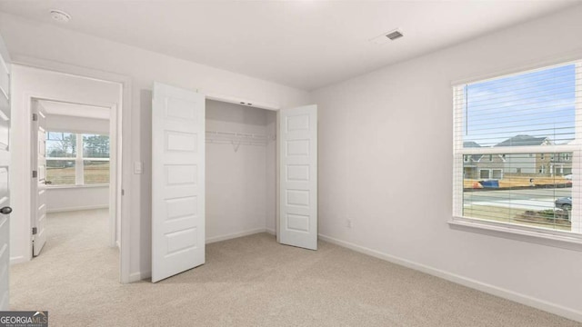 1099 Blue Juniper Cir, Loganville, GA 30052 - unfurnished bedroom featuring baseboards, visible vents, a closet, and light carpet
