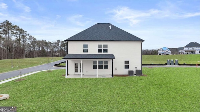 1099 Blue Juniper Cir, Loganville, GA 30052 - rear view of property featuring a patio, a shingled roof, a lawn, and cooling unit
