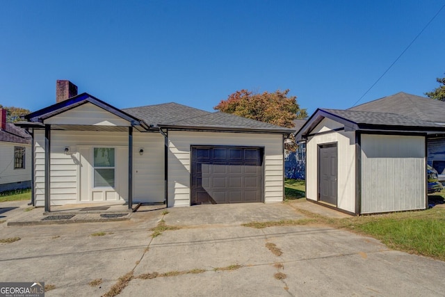 34 Ivy St, Porterdale, GA 30014 - ranch-style house featuring an attached garage, a chimney, an outbuilding, driveway, and a shingled roof