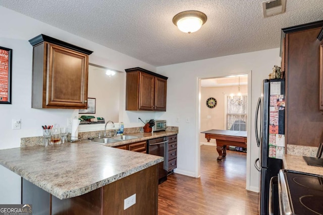 8166 N Pine Cone Dr, Villa Rica, GA 30180 - kitchen with stainless steel dishwasher, a sink, visible vents, freestanding refrigerator, and a peninsula