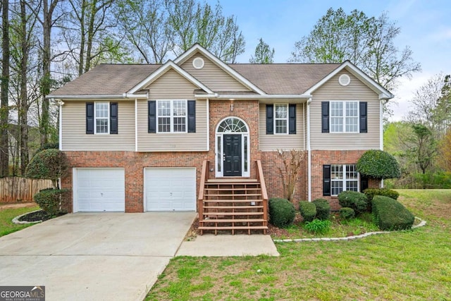 bi-level home with concrete driveway, fence, a front lawn, brick siding, and a garage