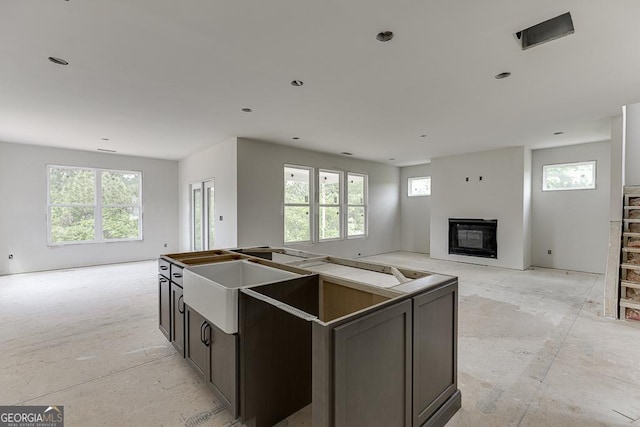 3748 Cheyenne Ln, Jefferson, GA 30549 - kitchen featuring open floor plan, a glass covered fireplace, a kitchen island, and a sink