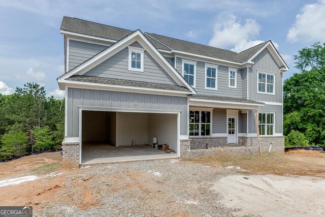 3748 Cheyenne Ln, Jefferson, GA 30549 - view of front of property with roof with shingles, driveway, board and batten siding, a garage, and brick siding