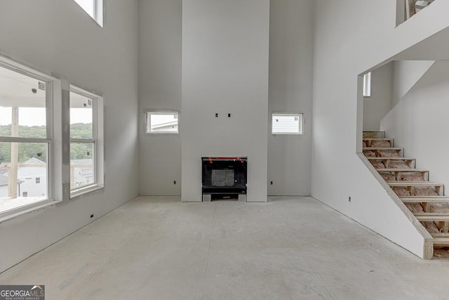 3787 Cheyenne Ln, Jefferson, GA 30549 - unfurnished living room featuring a towering ceiling, healthy amount of natural light, and stairway