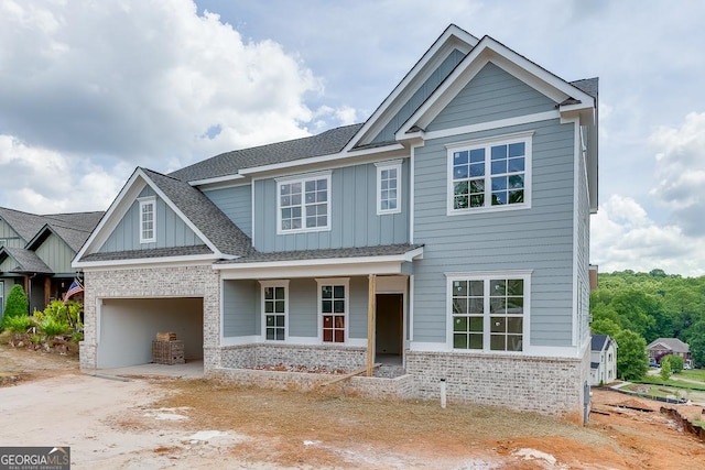 3787 Cheyenne Ln, Jefferson, GA 30549 - view of front of house featuring board and batten siding, a porch, brick siding, driveway, and an attached garage