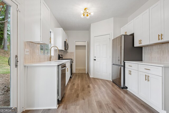 kitchen featuring light countertops, a sink, white cabinets, and appliances with stainless steel finishes