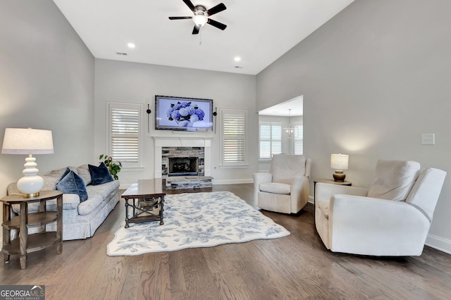 living area featuring baseboards, ceiling fan, visible vents, and wood finished floors