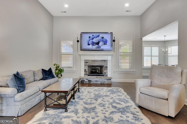 living room with baseboards, a fireplace, wood finished floors, and visible vents