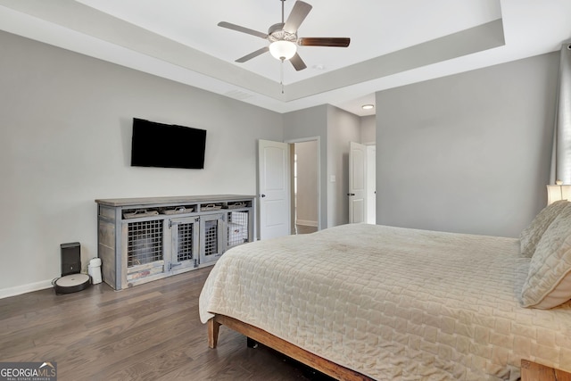 bedroom with a ceiling fan, wood finished floors, baseboards, a tray ceiling, and recessed lighting