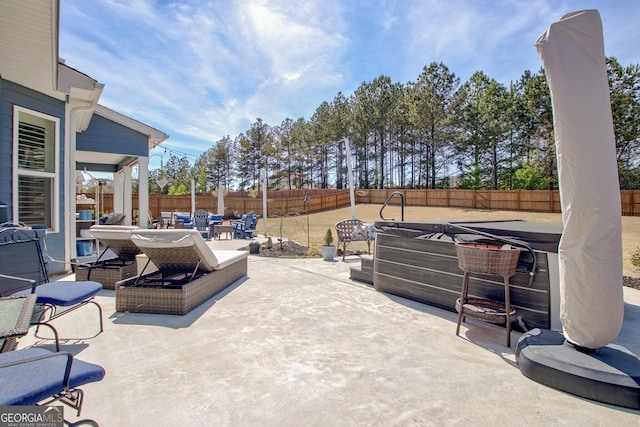 view of patio with outdoor dining area, a fenced backyard, and a hot tub