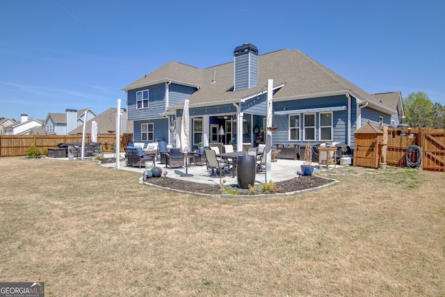 rear view of house with a patio, a fenced backyard, a lawn, and an outdoor living space