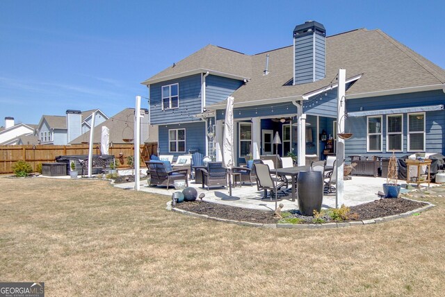 back of house with fence, a patio, a chimney, and a yard