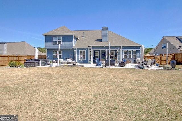 rear view of property featuring a hot tub, a fenced backyard, a chimney, an outdoor living space, and a patio
