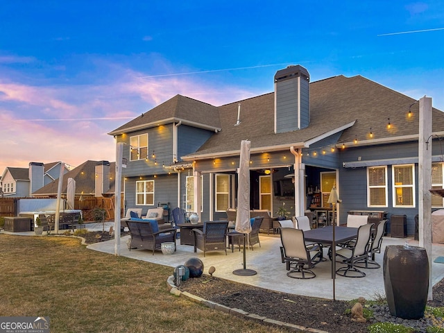 back of property featuring a yard, roof with shingles, outdoor lounge area, and a patio area