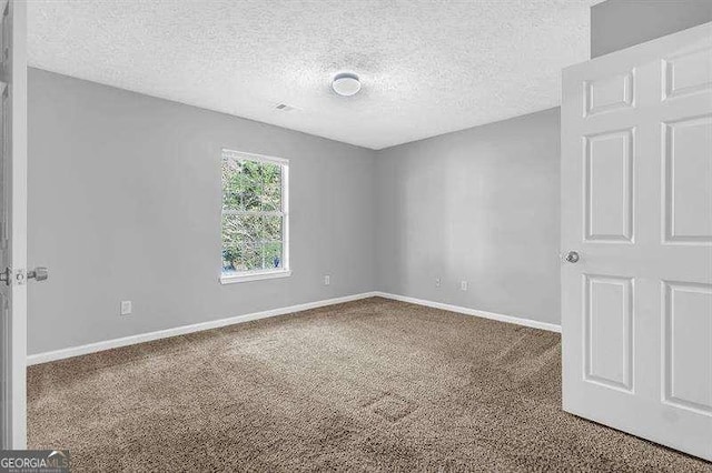 carpeted empty room featuring baseboards and a textured ceiling