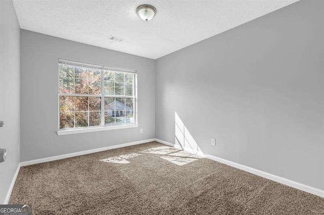 empty room featuring baseboards, carpet floors, and a textured ceiling
