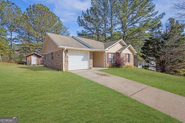 ranch-style home with an attached garage, driveway, a storage unit, a front yard, and brick siding