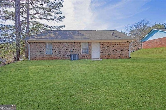 back of property featuring brick siding and a lawn