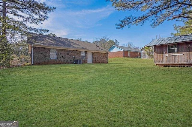 view of yard featuring cooling unit, an outbuilding, and a storage shed