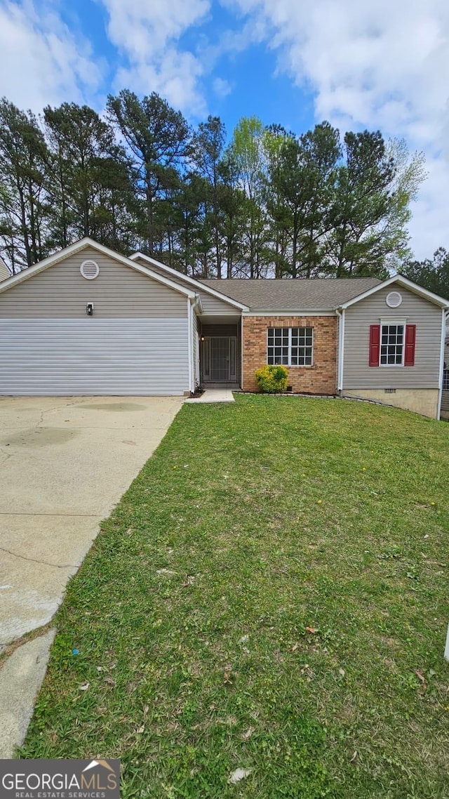 view of front of home featuring brick siding, a front yard, and driveway