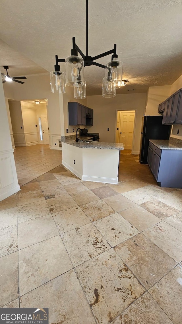 kitchen with open floor plan, a decorative wall, and a textured ceiling