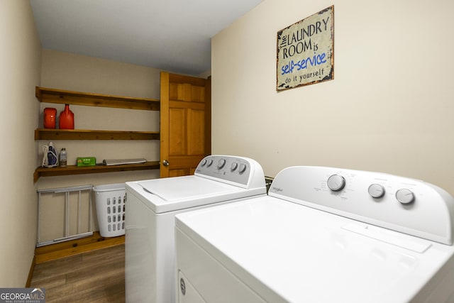 washroom with wood finished floors, washing machine and clothes dryer, and laundry area