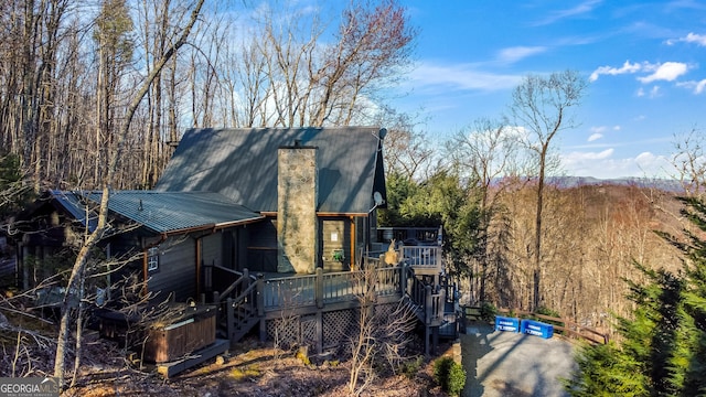 view of side of home with metal roof, stairs, and a deck