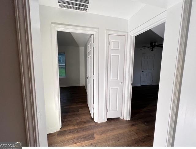 hall featuring visible vents and dark wood-style flooring