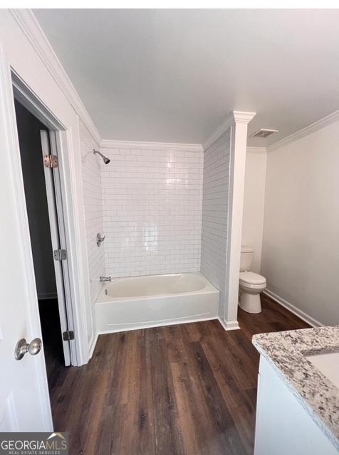 full bathroom with crown molding, bathtub / shower combination, wood finished floors, toilet, and vanity