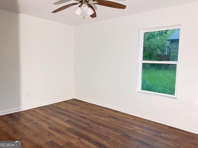 unfurnished room with a ceiling fan, dark wood-type flooring, and baseboards