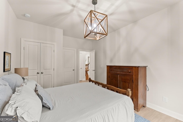 6635 Canyon Cv, Cumming, GA 30028 - bedroom featuring light wood finished floors, baseboards, a chandelier, and a closet