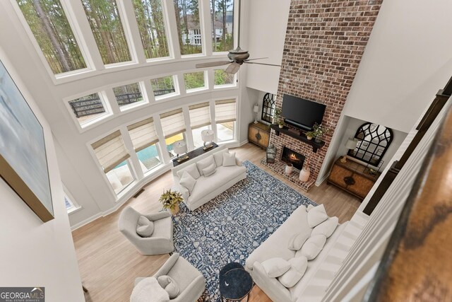 6635 Canyon Cv, Cumming, GA 30028 - living area featuring ceiling fan, wood finished floors, a towering ceiling, and a fireplace