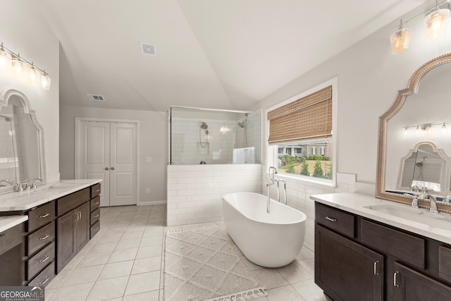 6635 Canyon Cv, Cumming, GA 30028 - bathroom with vaulted ceiling, a sink, a tile shower, tile patterned flooring, and visible vents
