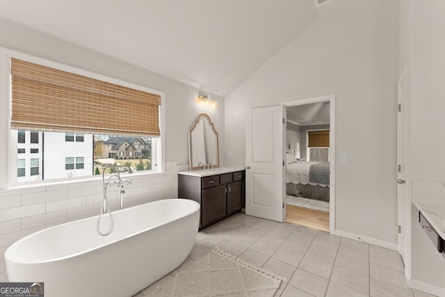 6635 Canyon Cv, Cumming, GA 30028 - ensuite bathroom featuring tile patterned floors, vanity, ensuite bath, a freestanding tub, and high vaulted ceiling