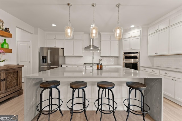 6635 Canyon Cv, Cumming, GA 30028 - kitchen with decorative backsplash, wall chimney exhaust hood, appliances with stainless steel finishes, and white cabinetry