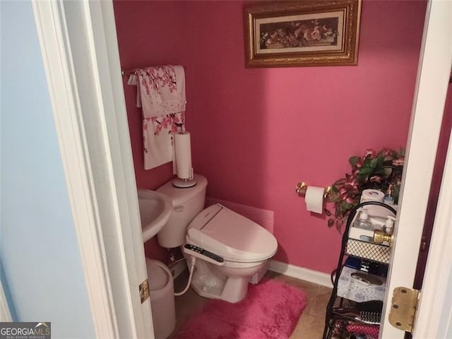 half bathroom with toilet and tile patterned flooring