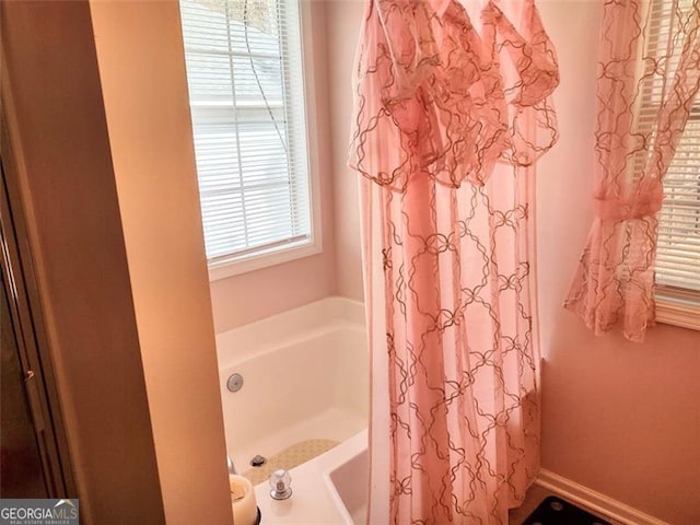 bathroom with curtained shower and a bathtub