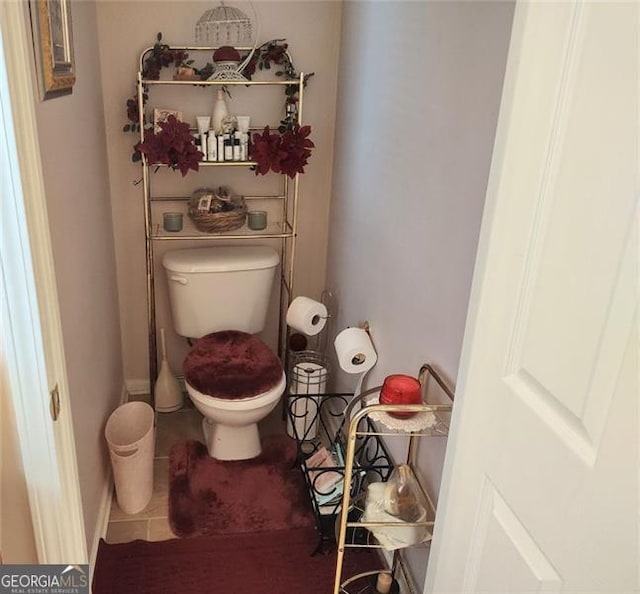 bathroom with tile patterned floors, baseboards, and toilet