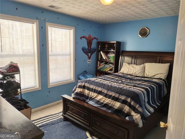carpeted bedroom featuring visible vents and a textured ceiling