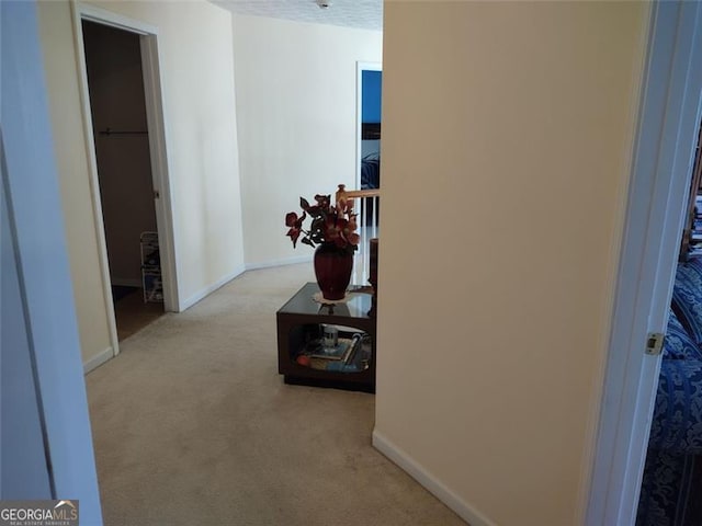 hallway featuring carpet floors and baseboards