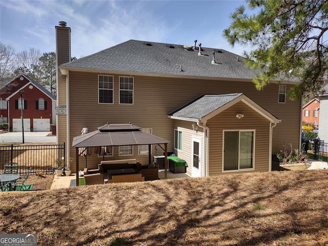 rear view of house featuring a chimney, an outdoor living space, a gazebo, fence, and a patio area