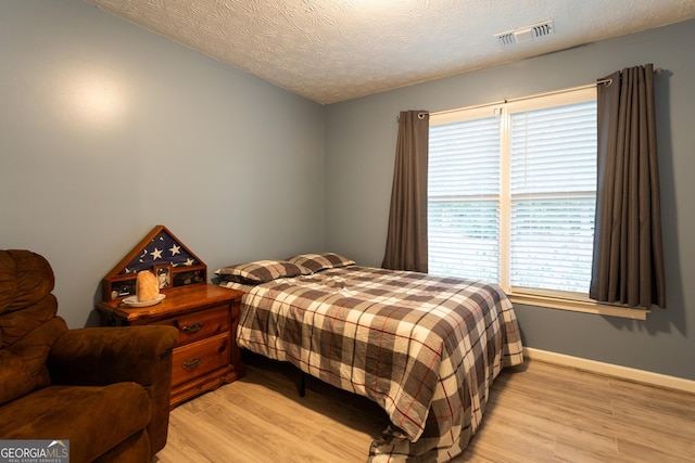tiled bedroom featuring baseboards, visible vents, and multiple windows