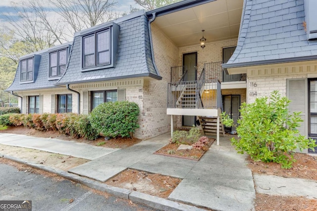 115 Woodmere Sq NW Unit 115, Atlanta, GA 30327 - exterior space with stairs, a shingled roof, mansard roof, and brick siding