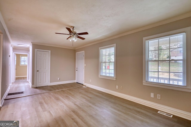 interior space featuring baseboards, visible vents, wood finished floors, and a healthy amount of sunlight